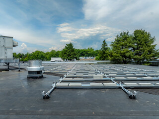 Photo of framing and concrete block ballast blocks for new solar panels being installed on a flat commercial, industrial EPDM roof.  