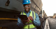 © peopleimages.com - Construction worker, man and tablet by truck for logistics with vehicle inspection for shipping and cargo export. Transport industry, site manager or black employee with app for maintenance and happy