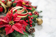 © Emanuel - Christmas wreath with red and gold ribbons and poinsettias on white
