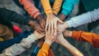 © nopommajun - This image captures a team-building moment with a top view of diverse hands joined in the center, symbolizing unity and teamwork