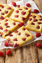 Wall Mural - Raspberry Custard Kuchen pie traditional and tasty German food closeup on the paper on the wooden table. Vertical