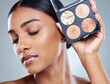 © peopleimages.com - Woman, makeup palette and beauty with eyes closed in studio for wellness, face and product for brand. Female person, cosmetology and pride with eyeshadow or blush for dermatology in studio background