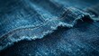© Alpha - High-angle shot of blue denim fabric, frayed ends, strong texture and depth, studio-lit isolated background, showcasing detailed fabric