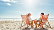 © peopleimages.com - Couple, relax and beach chairs on sand for vacation, holiday or weekend break. Summer, man and woman together in nature with water for peace, travel or tourism in bali getaway with view