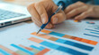 © 沈军 贡 - Closeup of hands holding pen and analyzing financial charts on the paper