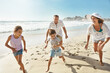 © ReadyAtTheEase/peopleimages.com - Running, playing and happy family at a beach with fun, bonding and freedom on summer, vacation and holiday. Travel, energy or excited kids with parents at ocean for adventure, journey or race in Bali