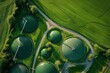© DK_2020 - Aerial view of green biogas plant storage tanks in green fields