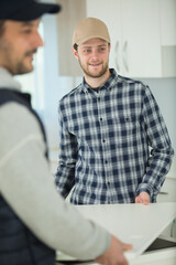 two men carrying component of fitted kitchen