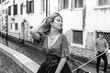 © T.Den_Team - Vacation in Venice - Italy. Concept of tourism and holidays. Beautiful seductive Woman in city scene, gondola and gondolier on background