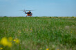 © Алексей Игнатов - Orange helicopter on a green meadow with yellow flowers preparing to take off. Sunny summer day. Foreground blur.