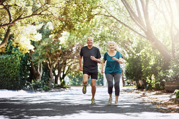 Wall Mural - Running, outdoor and old couple with sunshine, exercise and bonding together with retirement. Park, senior man and mature woman with training, challenge and hobby with fitness, summer and wellness