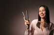 © Pixel-Shot - Beautiful young woman with hair straightener on pink background