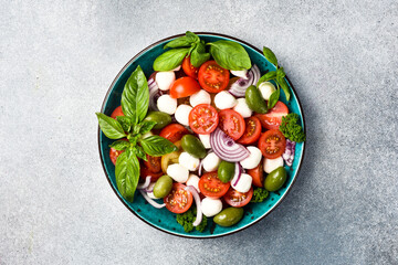 Sticker - Traditional Italian salad: tomatoes, mozzarella cheese, basil and olives. Caprese. On a gray concrete canvas.