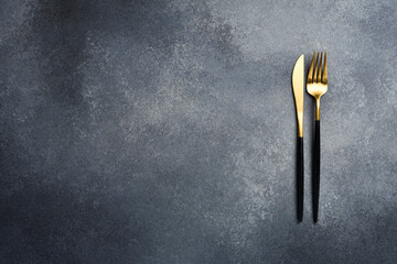 Wall Mural - Cutlery: fork and knife. On a gray stone background. Free space for text.