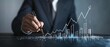 © QuietWord - businessman hand  drawing a graph with pen, doodle graph upward trend, business and financial concept
