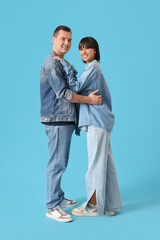 Wall Mural - Young couple in love hugging on blue background