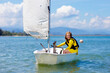 © famveldman - Child sailing. Kid learning to sail on sea yacht.