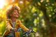 © Tanya - Happy smiling African American boy with curly hair riding a bicycle in a summer park on a sunny day. Copy space.