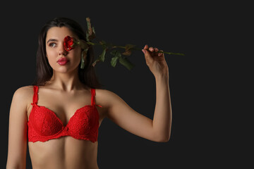 Sticker - Beautiful young woman in sexy red lingerie with rose flower on dark background