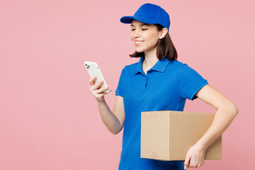 Sticker - Professional delivery girl employee woman wear blue cap t-shirt uniform workwear work as dealer courier holding cardboard box use mobile cell phone isolated on plain pink background. Service concept.