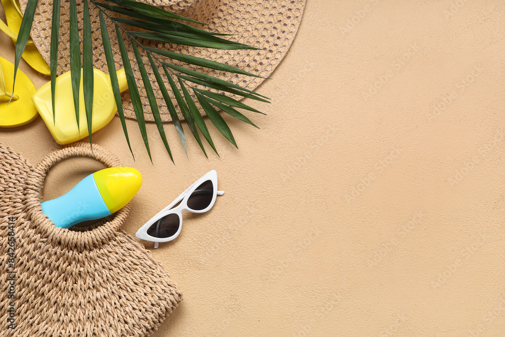 Beautiful composition with beach accessories and bottles of sunscreen on beige background