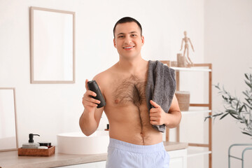 Wall Mural - Handsome young man with deodorant in bathroom