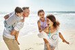 © peopleimages.com - Happy family, walking and piggyback at beach in summer for relax, travel and holiday in Miami. Parents, children and people at ocean with back ride for vacation, trust and bonding together by water