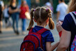 © 7707601 - Girl with pigtails with a backpack on her back goes to school with mother, her back is turned. Back to school.