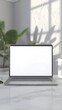 © MstHafija - 3D rendering of a white laptop mockup with a blank screen on a desk next to a phone and mouse, a green plant in a pot on the side, white background