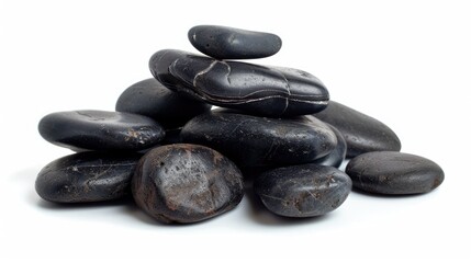 Spa hot stones arranged in a pile against a white backdrop