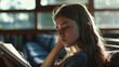 © VK Studio - A young girl deeply engrossed in a book, with sunlight filtering through the window, creating a warm and studious atmosphere.