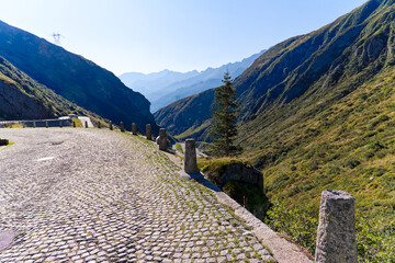 Wall Mural - Scenic view of mountain pass road named Tremola at Swiss mountain pass Gotthard on a sunny late summer day. Photo taken September 10th, 2023, Gotthard, Canton Ticino, Switzerland.