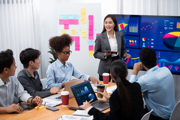 Wall Mural - Young asian businesswoman presenting data analysis dashboard on TV screen in modern meeting. Business presentation with group of business people in conference room. Concord