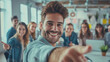 © Michael - Cheerful young man reaches for a handshake in a modern office setting with colleagues