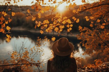 Wall Mural - Tranquil Autumn Sunrise Over Lake with Woman in Hat