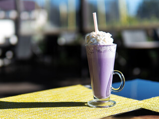 Wall Mural - blueberry milkshake with whipped cream on the table in the cafe