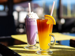 Wall Mural - Bumble coffee, espresso with orange juice and blueberry milkshake on the table in the cafe