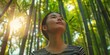 © LukaszDesign - Thinking, bamboo, and Japanese woman in forest for holiday, vacation, and morning adventure. Kyoto outdoor exploration, wandering, and independence with natural vegetation in woodlands