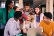 © CarlosBarquero - Group of young university students smiling using laptop computer at class room table on campus. Cheerful multiracial people working together on project in faculty. Online education in generation z