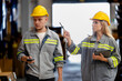 © ultramansk - man and woman worker walking and checking stock for shipping. Female inspecting the store factory. Logistics employees holding folders at on site warehouse area for shipping transportation.