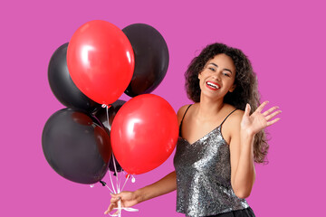 Beautiful African-American woman with balloons waving hand on purple background. Black Friday sale