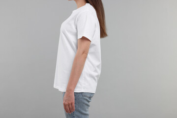 Woman in white t-shirt on grey background, closeup