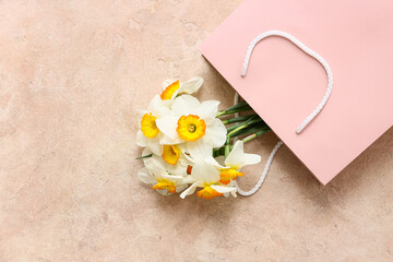 Wall Mural - Shopping bag with beautiful daffodil flowers on beige background