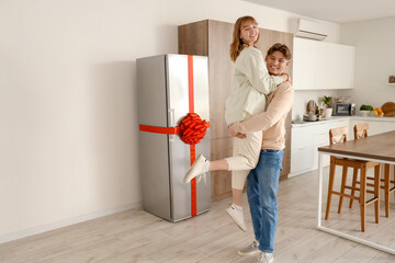 Sticker - Happy young couple with gift fridge in kitchen