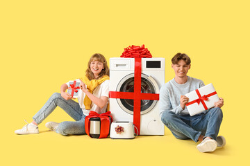 Poster - Young couple with gift appliances on yellow background