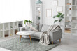 © Pixel-Shot - Cozy sofa with plaid and cushions, coffee table, shelving units and frames on wall in living room