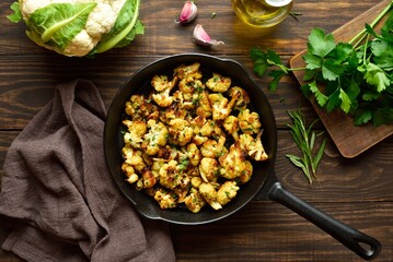 Wall Mural - Roasted cauliflower in cast iron pan on wooden background
