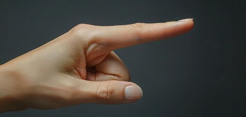 Close-up image of a pointing hand with a dark background