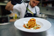 © Drazen - Close up of chef finishing dish before serving it to a guest in restaurant.