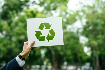 Businessman holding a sign recycle reuse reduce on nature background for zero waste concept and environmental sustainability. CSR corporate social responsibility. eco friendly design product